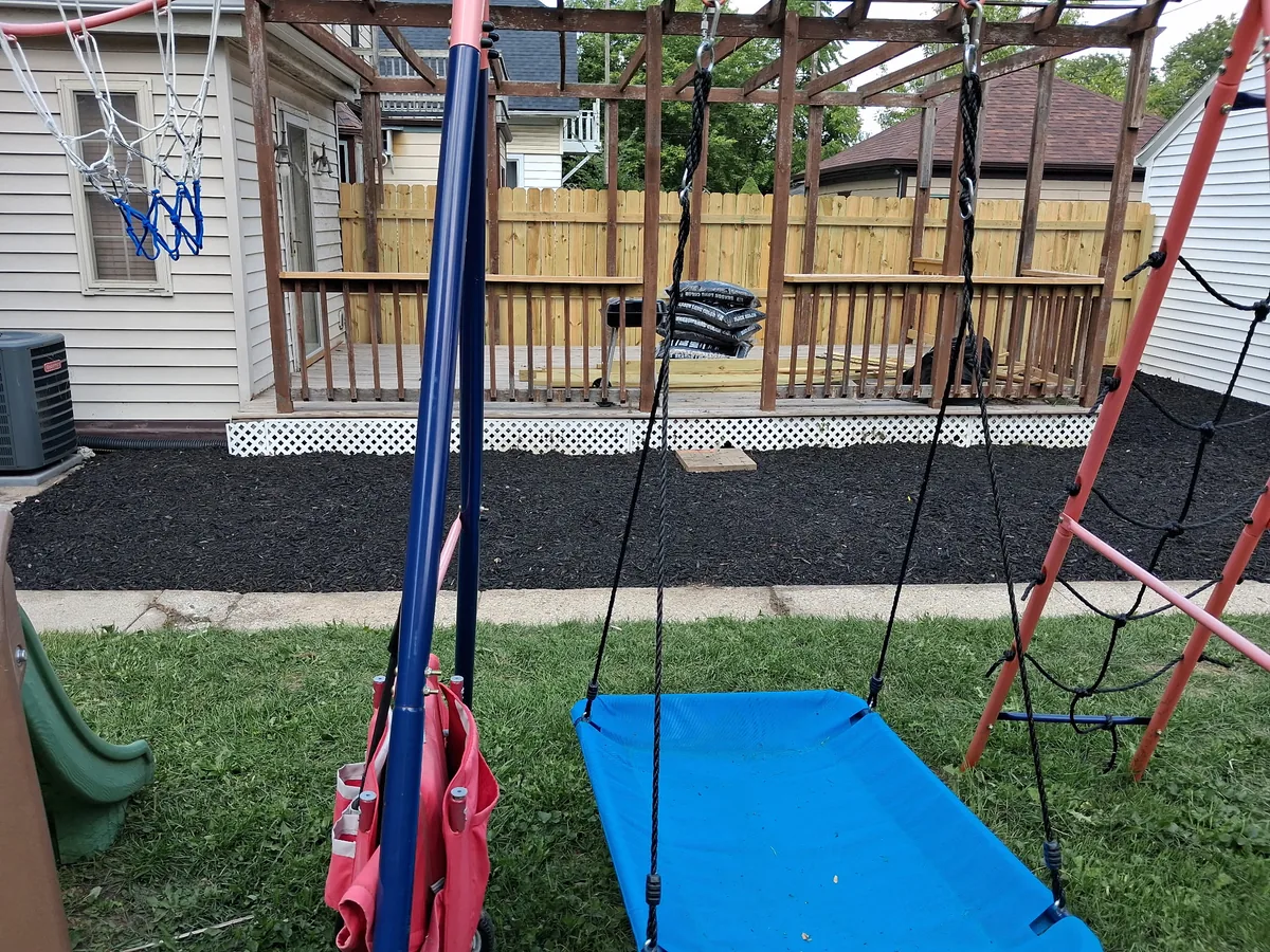 Black mulch spread under a backyard swing set