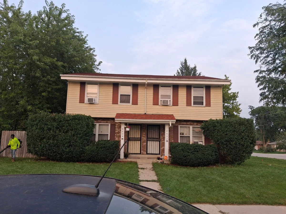 Mowed front lawn and trimmed shrubs at a two story home